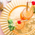 Overhead image of a gold try with two Jungle Bird Rum Cocktails in highball glasses garnished with fruit birds