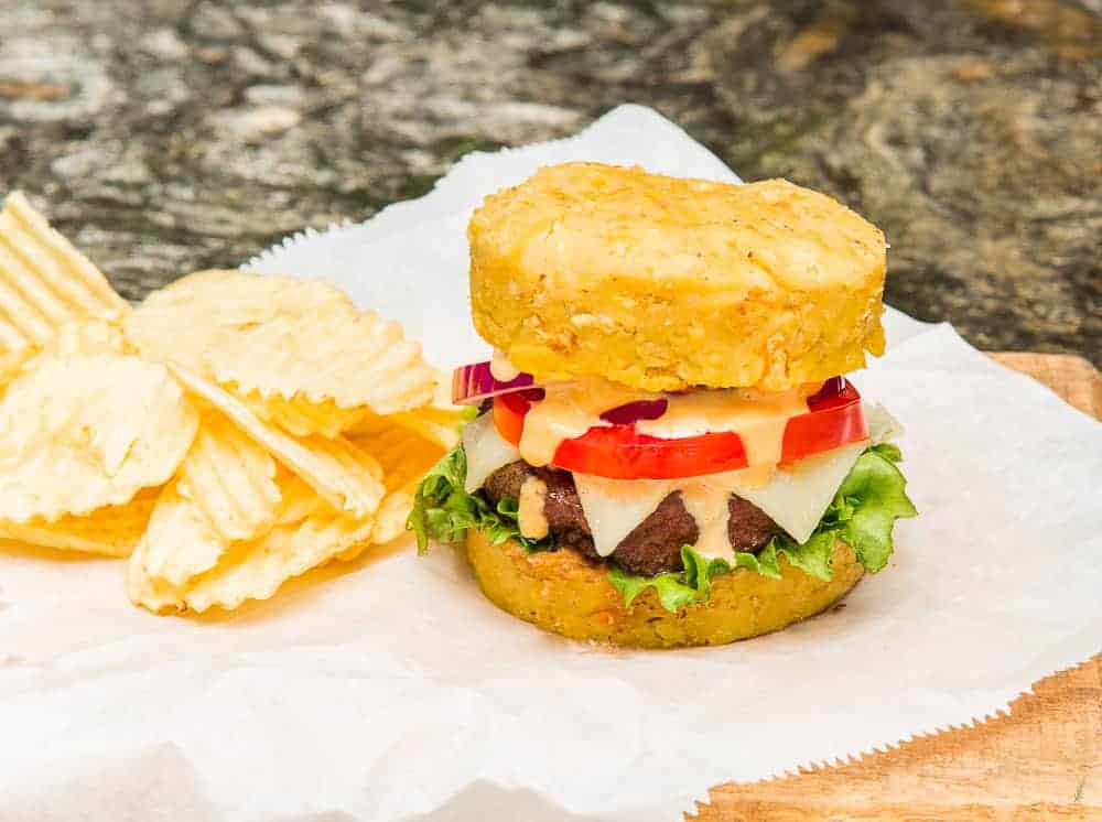 A Mofongo Burger topped with lettuce, tomato, onions, cheese and burger sauce