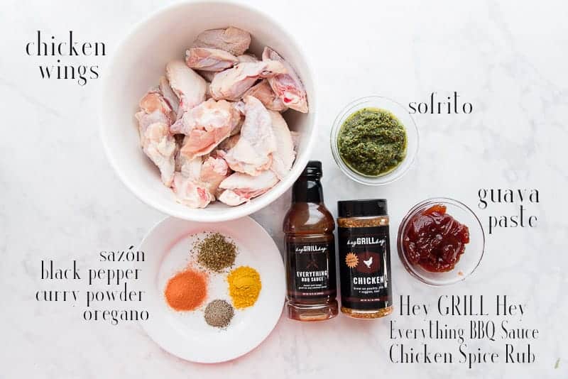 The ingredients to make Guava BBQ Air Fryer Chicken Wings: chicken wings, sofrito, guava jelly, spice rub, BBQ sauce, spices