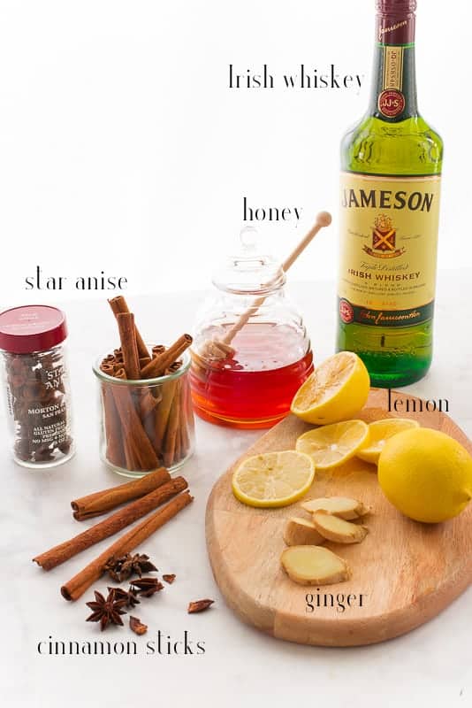 Ingredients for Classic Hot Toddy pictured: Irish whiskey, honey, lemon, ginger, cinnamon sticks, and star anise.