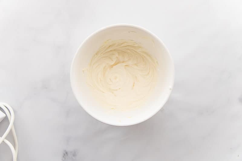 The cream cheese filling mixed in a small, white bowl