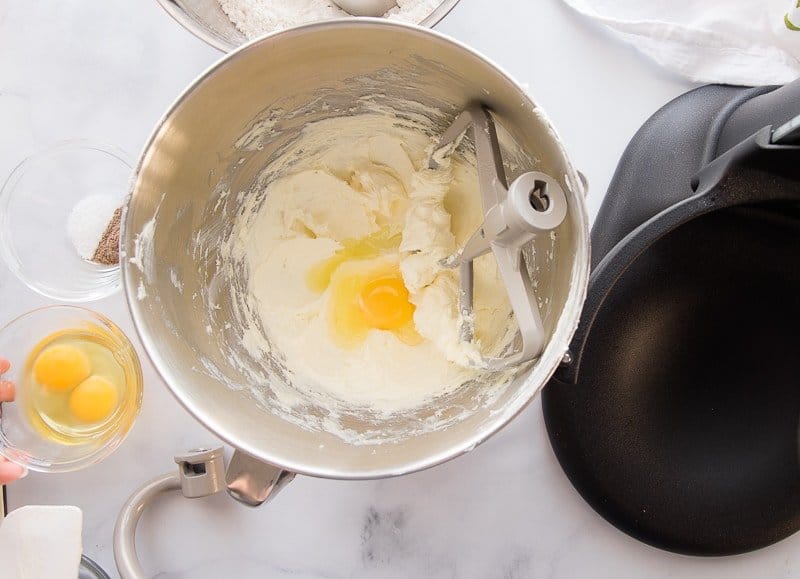 Eggs are added to the mixer bowl with the butter and sugar.