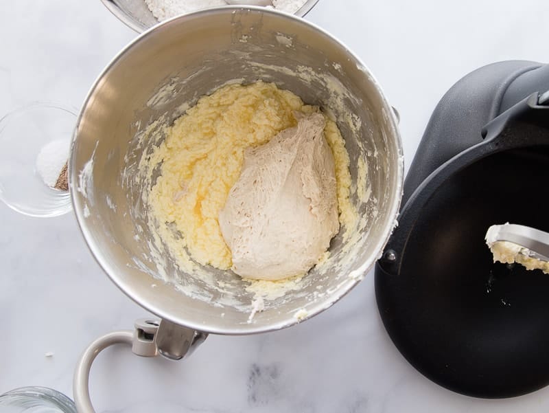 The bowl of stand mixer shows the butter and eggs mixture with the starter added to it.