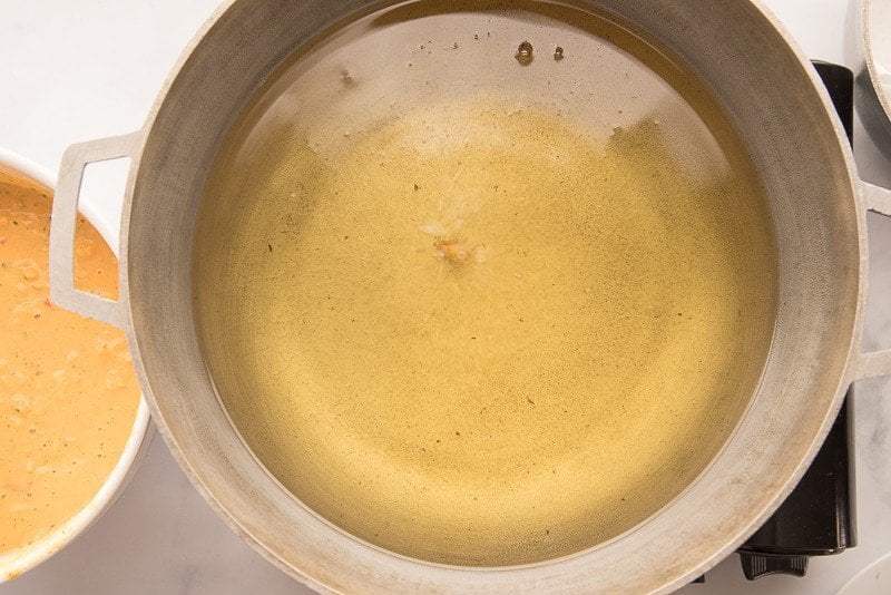 A small amount of fritter batter is dropped into the oil to check the temperature