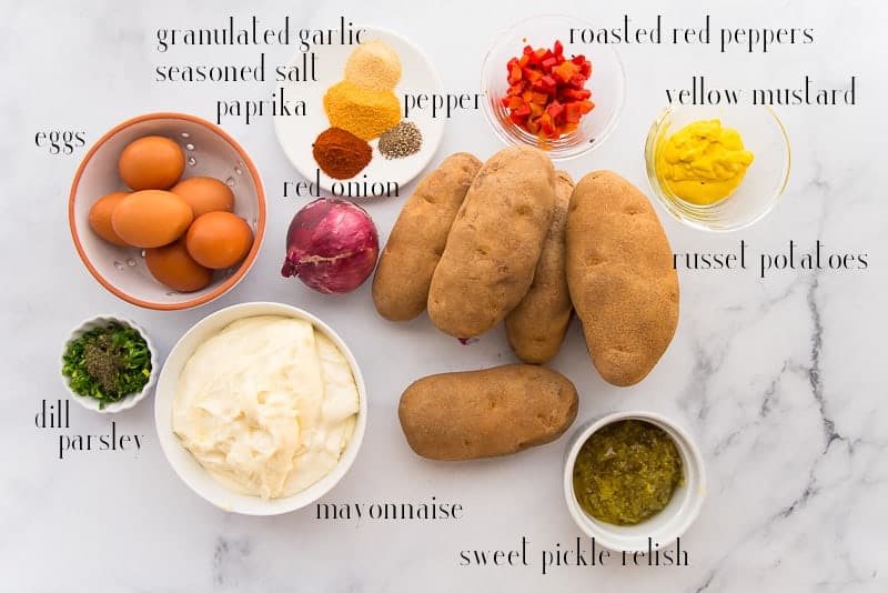 Ingredients to make Country-Style Potato Salad: eggs, spices, red peppers, mustard, potatoes, sweet relish, mayo, and herbs.