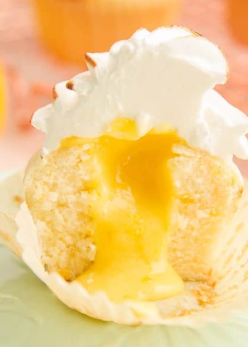Image showing the inside curd filling of a Lemon Meringue Cupcake on a green plate. Peach text overlay: Lemon Meringue Cupcakes