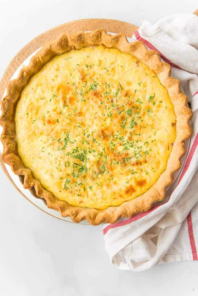 Lead image of a quiche lorraine next to a white kitchen towel