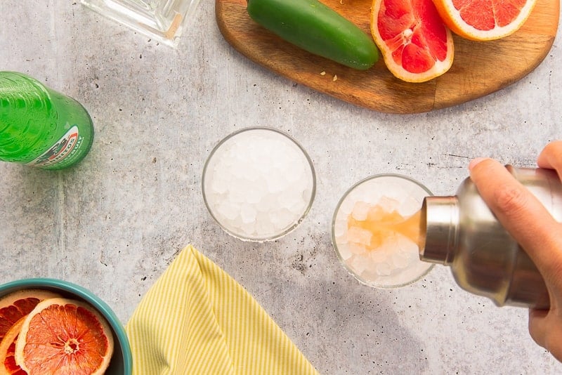 The spicy paloma mix is poured into an ice-filled highball glass