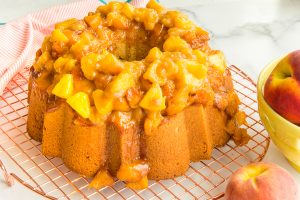 Preview image of the baked Remy Pound Cake with Peach Topping on a copper cooling rack