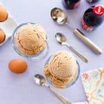 Overhead horizontal image of two glasses of scoops of Ponche Frozen Custard on a purple surface.