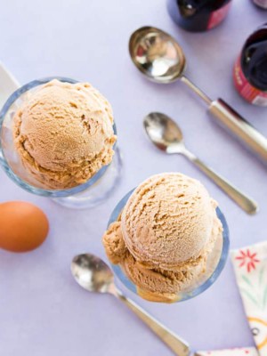 Overhead horizontal image of two glasses of scoops of Ponche Frozen Custard on a purple surface.