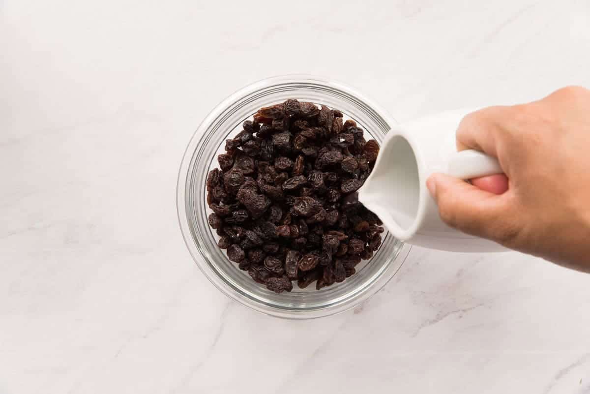 Hot water is added to the raisins to rehydrate them before adding them to the budin.