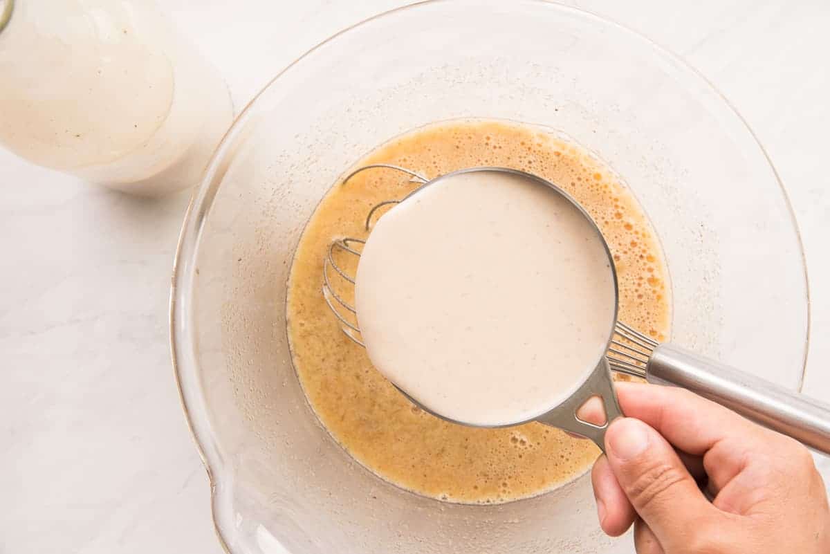 Coquito is added to the egg and sugar mixture.