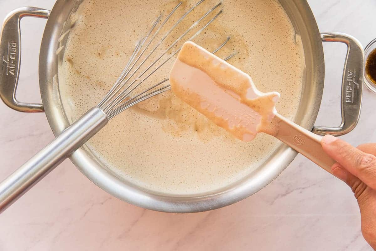 A finger run through the custard on a rubber spatula leaves a line to show the custard is thickened properly.