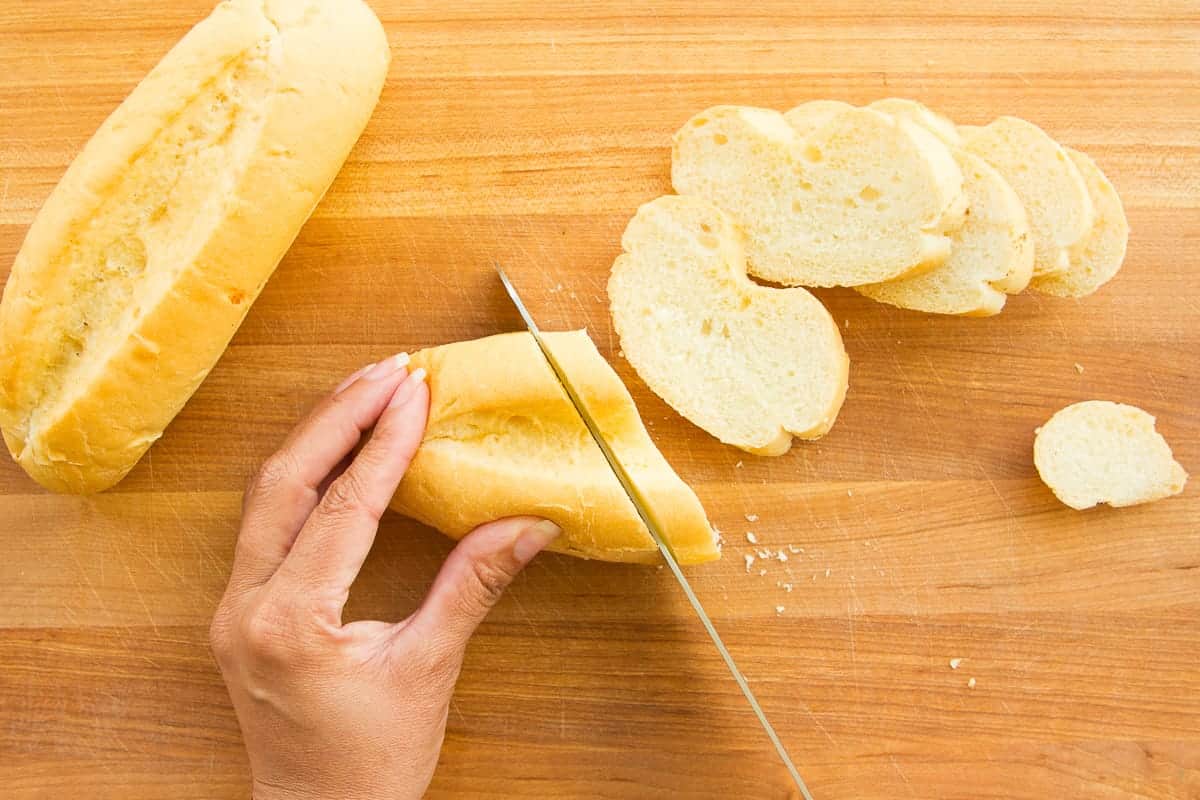 Mexican bolillo bread is sliced before toasting.