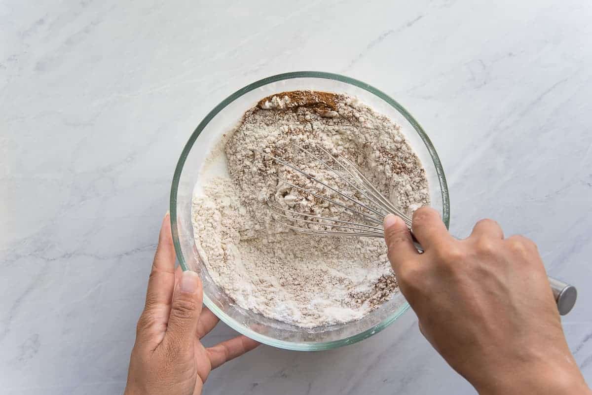 The dry ingredients are whisked together in a glass mixing bowl.