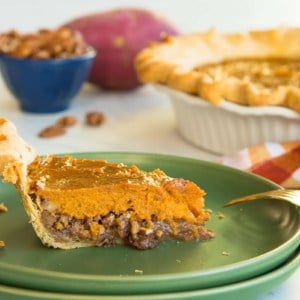Preview image of a slice of Sweet Potato Maple Pecan Pie on a green plate. The rest of the pie is in the right background.
