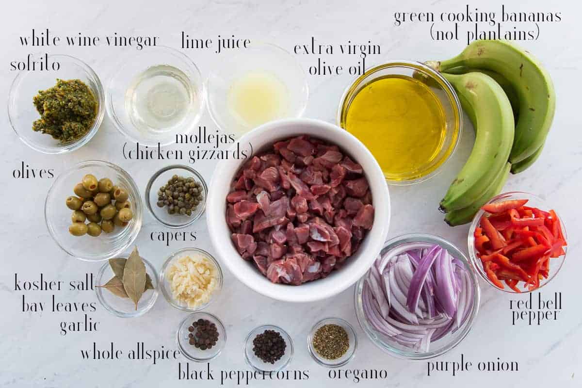 Ingredients to make Guineitos con Mollejas en Escabeche: sofrito, white wine vinegar, lime juice, olive oil, green cooking bananas, bell pepper, purple onion, oregano, peppercorns, allspice, garlic, bay leaves, salt, olives, capers, and chicken gizzards.
