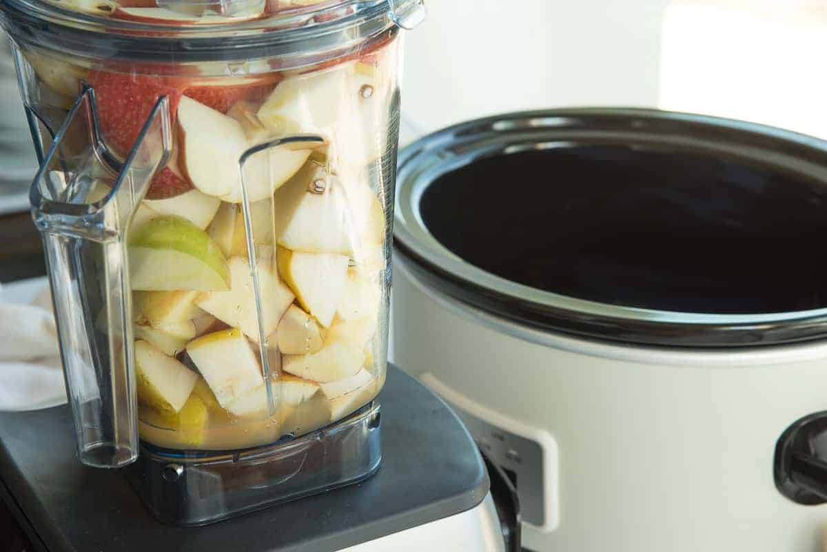 The fruits are added to the blender with apple cider.