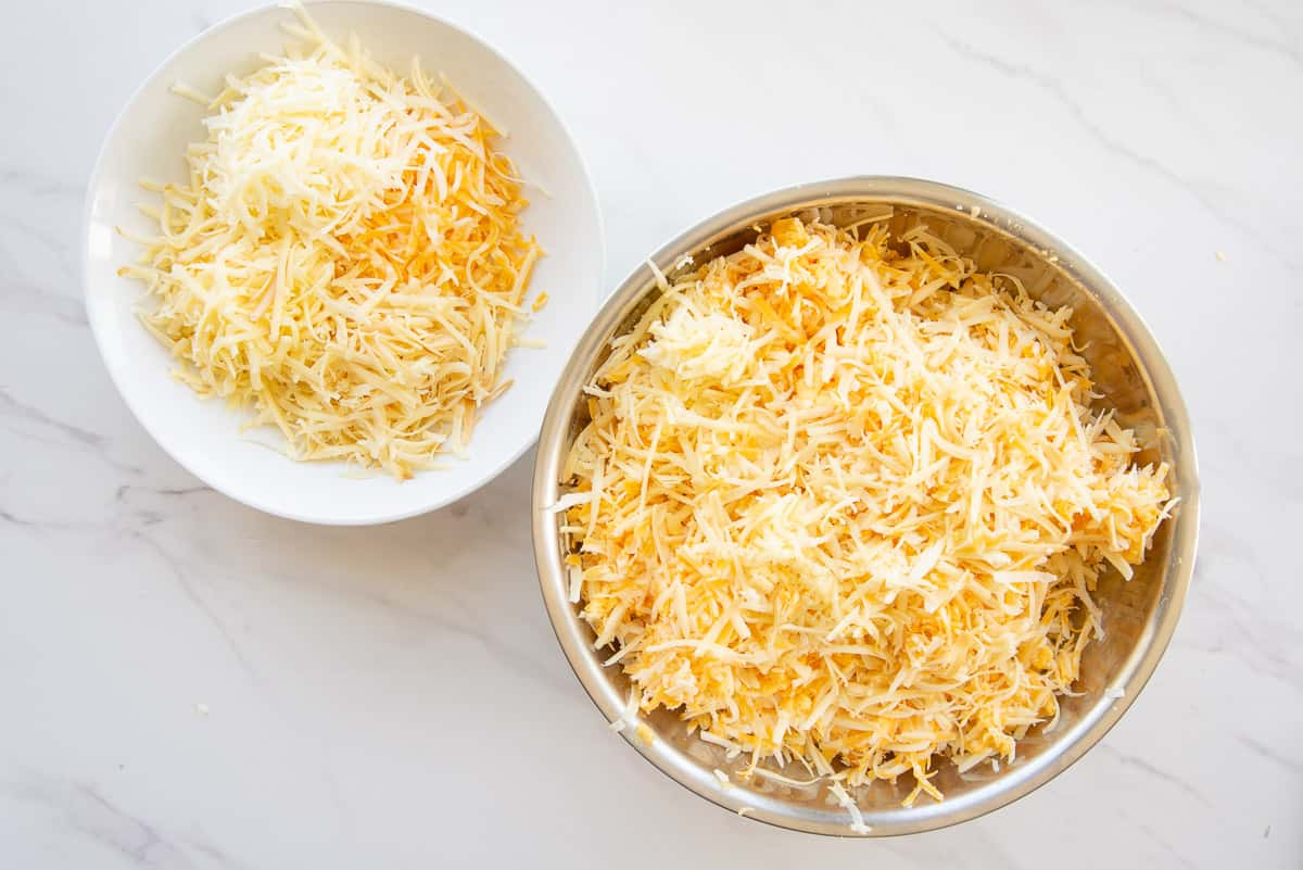 Two portions of shredded cheese are separated for the recipe.