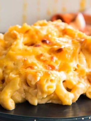 A serving of Five Cheese Baked Macaroni and Cheese on a dark blue plate.