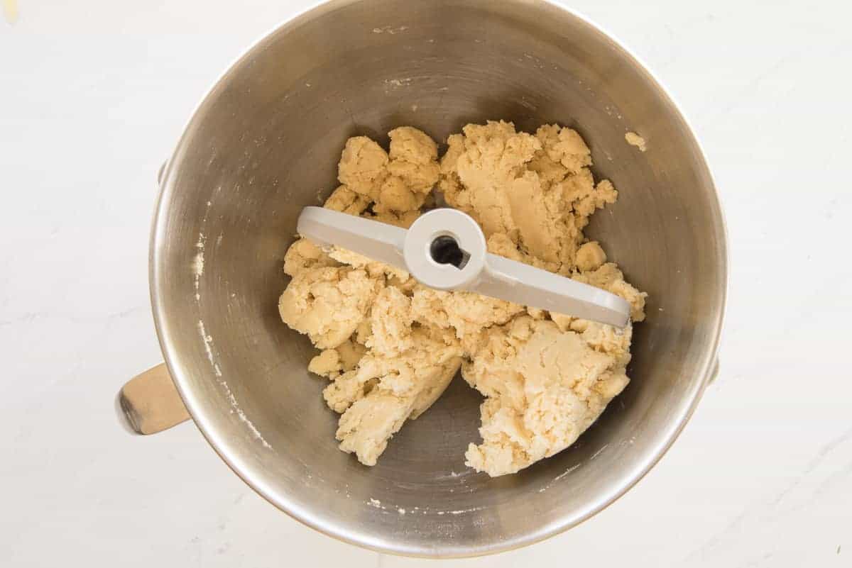 The flour and butter mixture are combined with the paddle attachment of a stand mixer to create the mealy pie dough.