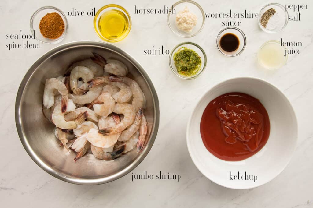 Ingredients needed to make Roasted Shrimp Cocktail with Homemade Sauce seafood spice blend, olive oil, horseradish, sofrito, worcestershire sauce, pepper, salt, lemon juice, ketchup and shrimp.