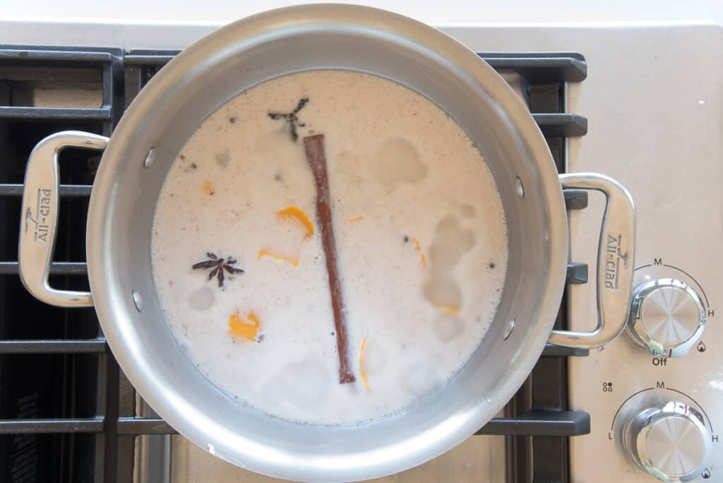 The coconut milk and spices simmer in a pot.