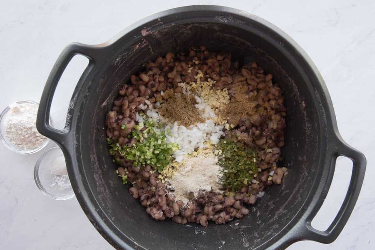 The aromatics and spices are added to the black pot.