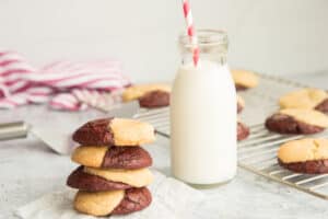 Backup preview image: Horizontal image of a stack of Red Velvet Snickerdoodle Brookies next to a milk bottle with a red and white striped straw in it.