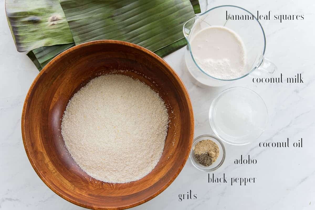 Ingredients to make the coconut grits cakes are pictured: grits, banana leaf squares, coconut milk, coconut oil, adobo, and black pepper.