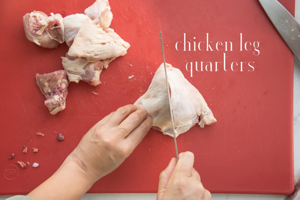 Chicken leg quarters are cut into 2-inch chunks on a red cutting board. White text overlay says chicken leg quarters.