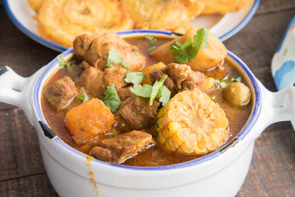 Close-up, horizontal image of a white bowl filled with Sancocho.