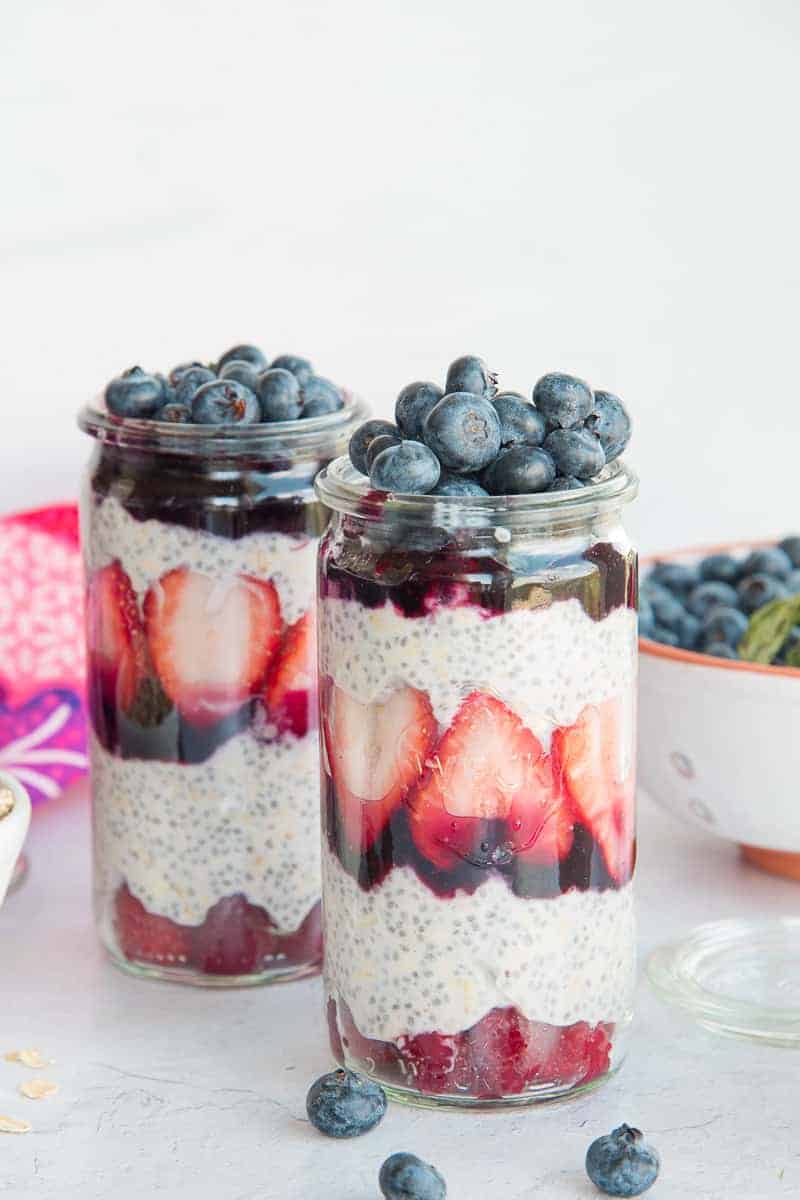 Portrait image of two tall weck jars filled with Chia Oats Fruit Parfaits
