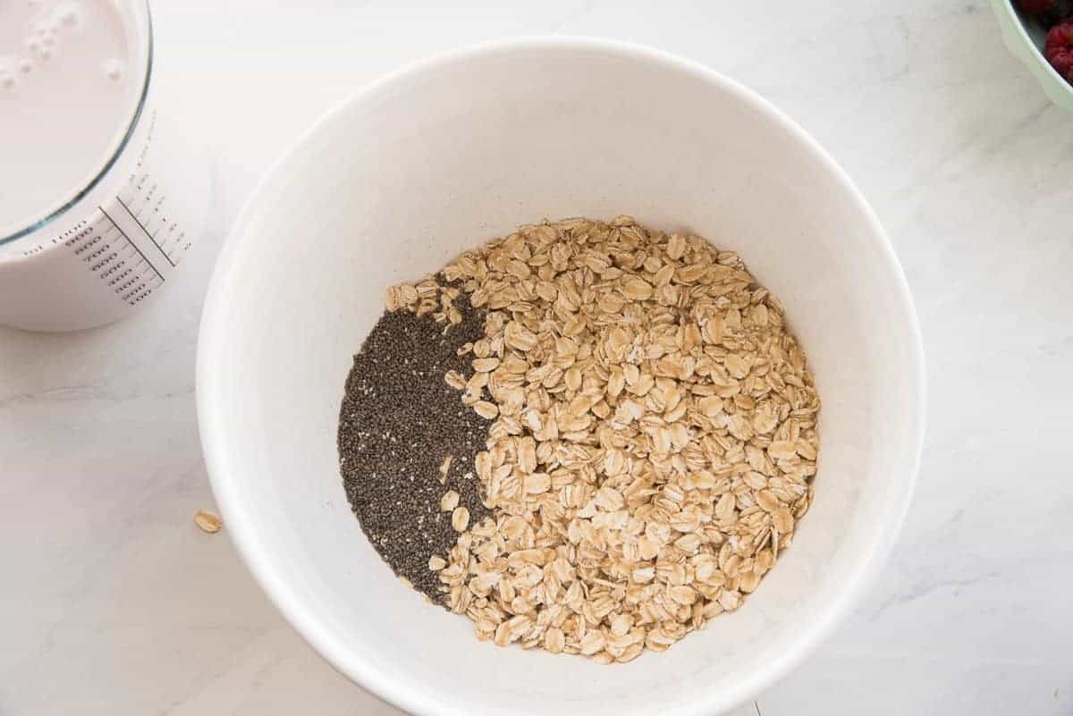 The oats and chia seeds are in a white ceramic mixing bowl.