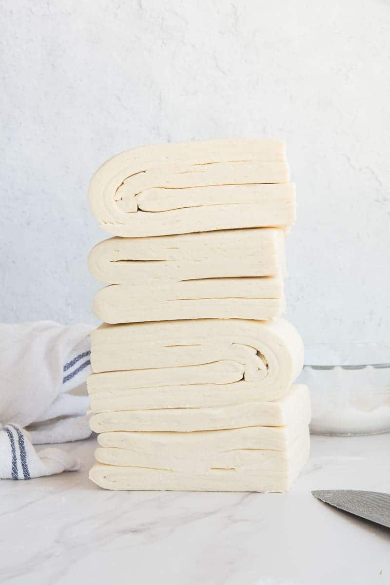 Four pieces of raw Puff Pastry stacked on each other.