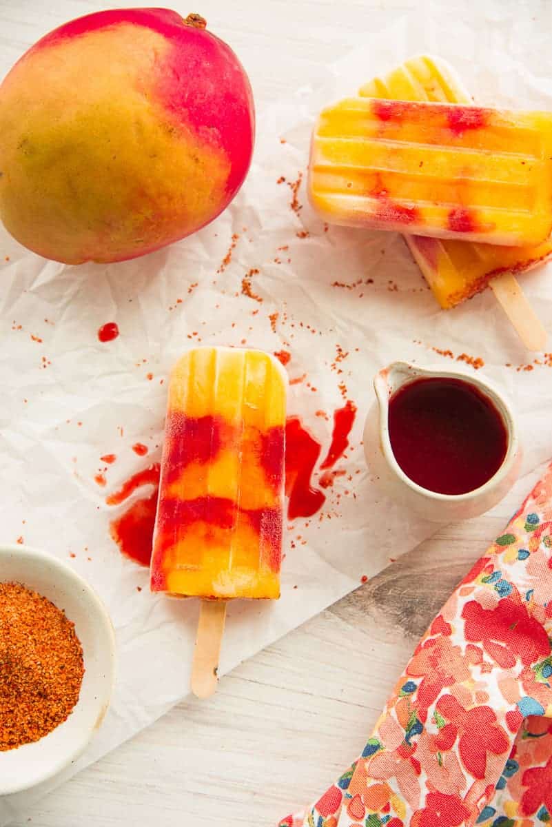 A Mango Rosewater Paletas with Chamoy is drizzled with chamoy