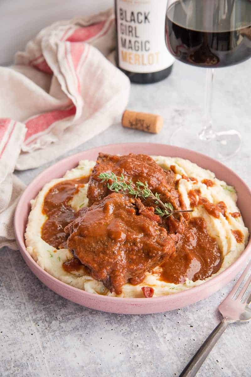 Lead image of Merlot Braised Short Ribs in a pink bowl.