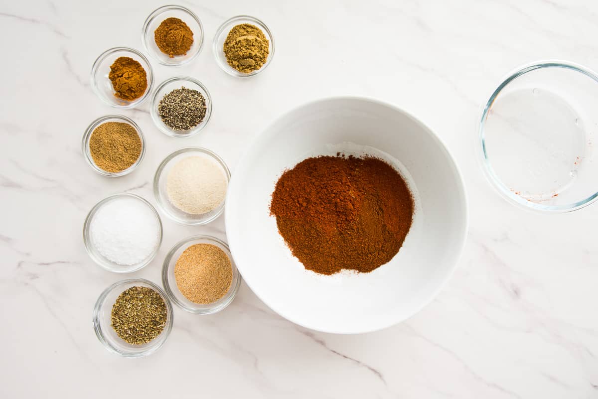 The chile powders are added to a white mixing bowl.