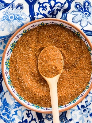 A bowl filled with the Mexican Four Chile Spice Blend on a blue mosaic surface.