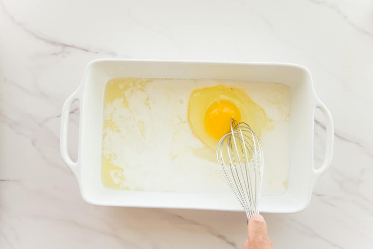The milk, lemon juice, and egg are whisked together in a white ceramic dish.