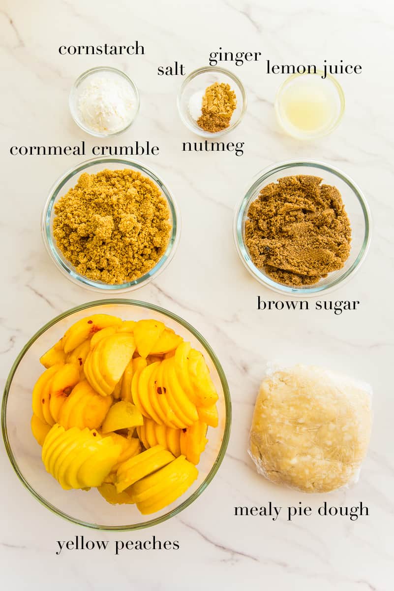 The ingredients needed to make the Peach Pie with Cornmeal Crumble Topping on a white countertop.