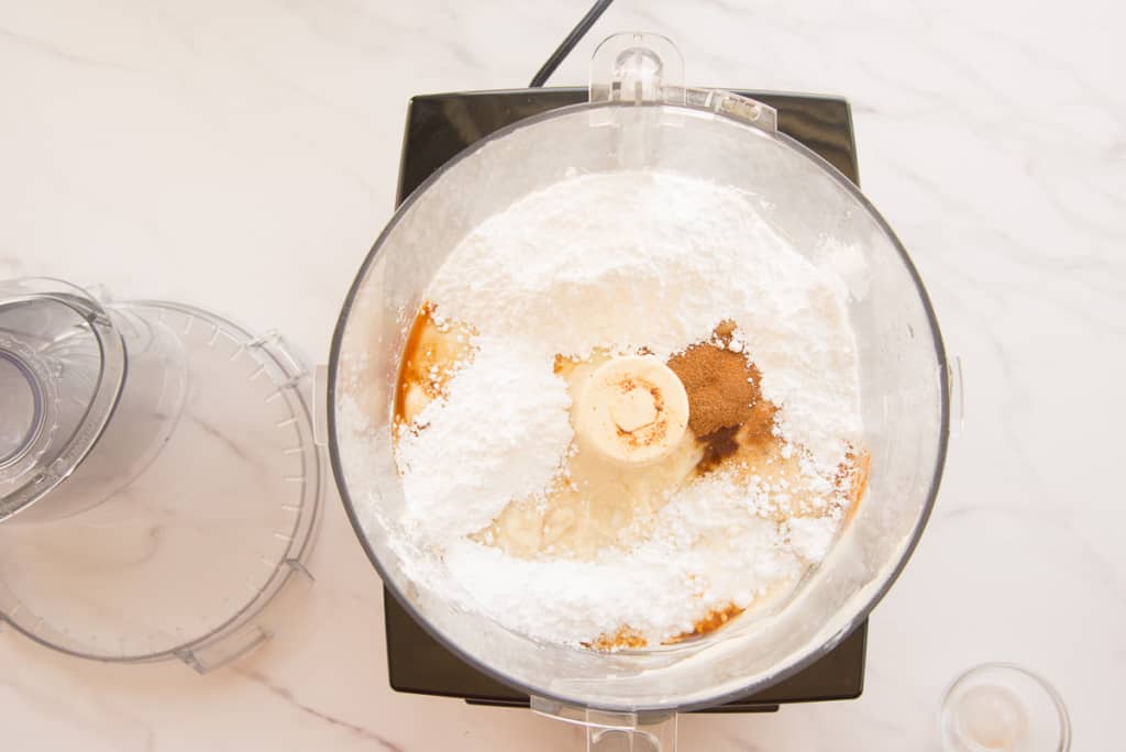 The sugar, spices, and extracts are added to the food processor.