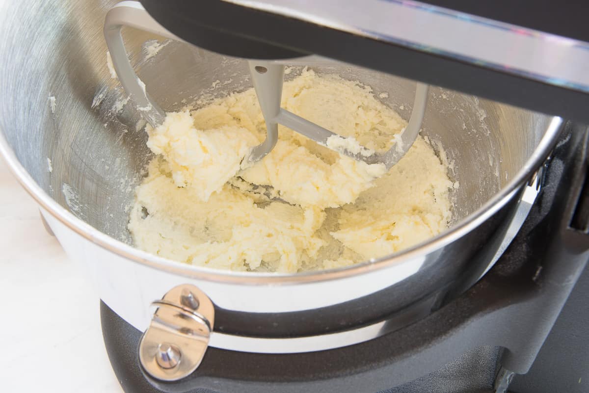 The sugar and butter are creamed until light in color in the bowl of a stand mixer.