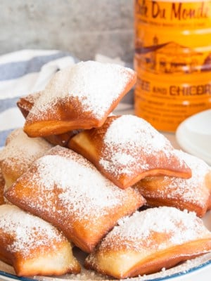 A stack of Beignets with powdered sugar on them.