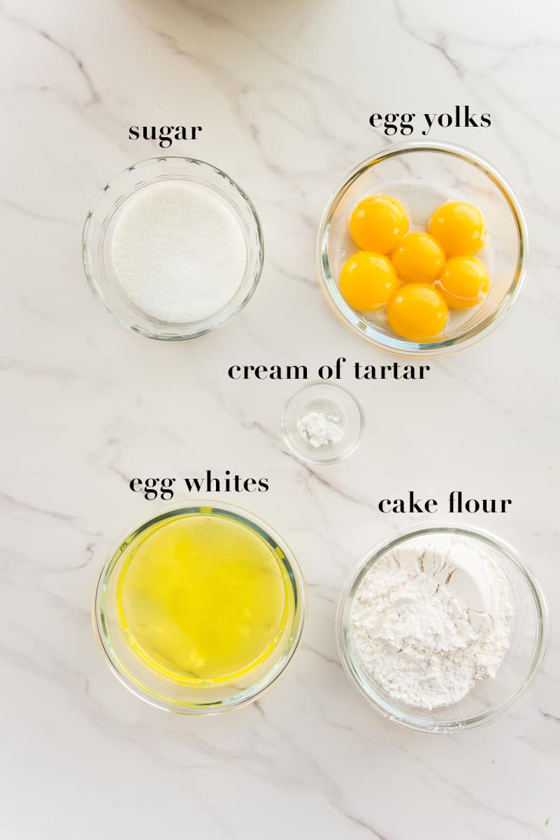 The ingredients to make the sponge cake are listed on a white surface.
