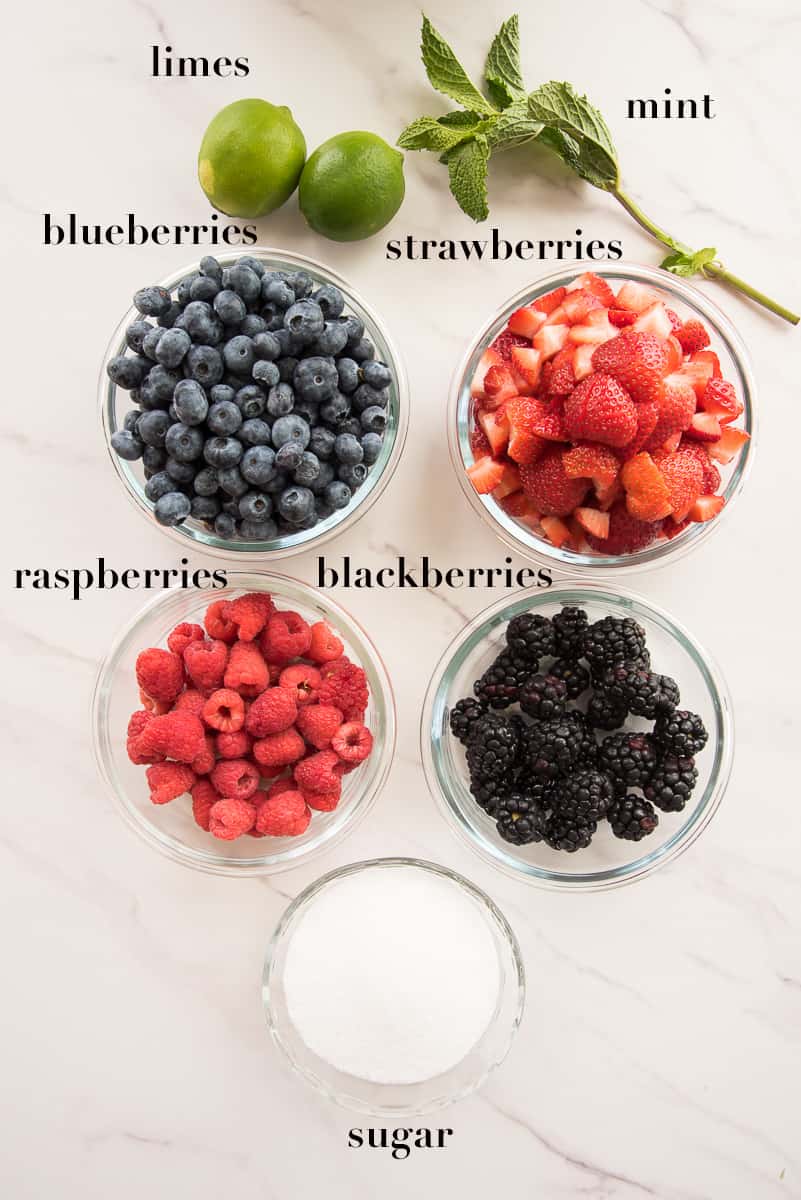 The ingredients to make the berry mixture are labeled and on a white surface.