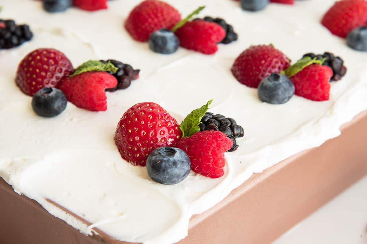 Close up of a cluster of fresh berries arranged on top of the whipped cream.