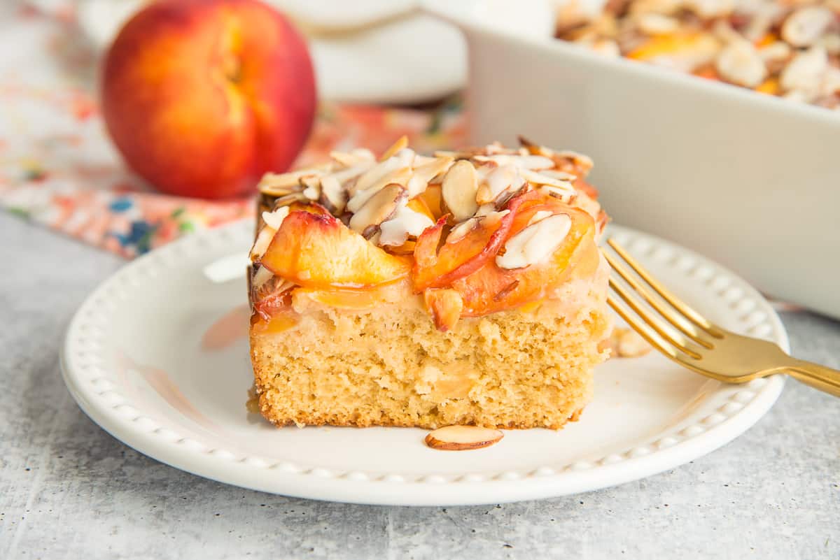 A slice of Nectarine Almond Coffee Cake on a white plate.