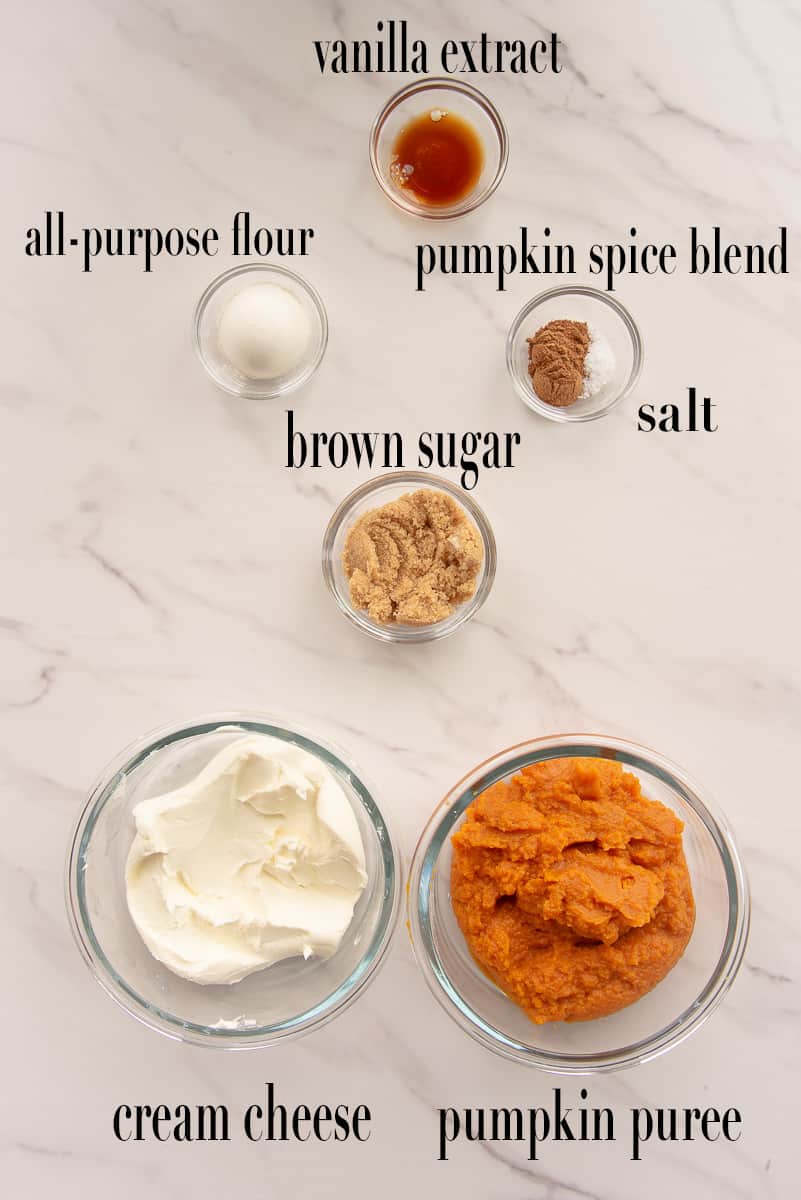 The ingredients to make the pumpkin cheesecake filling are labeled and on a white surface.